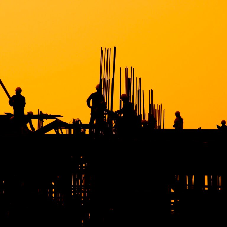 Construction workers at sunset.